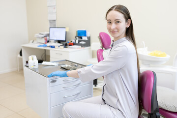 Portrait of female dentist. She's standing in her dentist office.