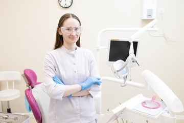 Portrait of female dentist. She's standing in her dentist office.