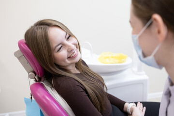 Dentist with patient in office. Happy woman visiting a dentist office