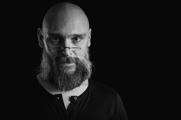 Black and white portrait of bearded man making silence gesture with finger on...