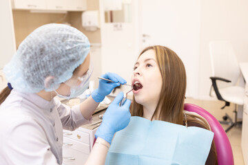 The dentist examines the patient's oral cavity. teeth