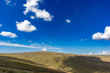 Scenic view of rolling hills under a blue sky with cumulus clouds casting shadows, Wensleydale, Yorkshire Dales, England