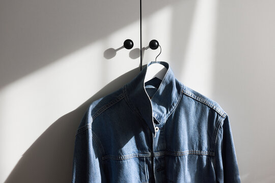Denim Jacket Hanging on Door Hook in Sunlight
