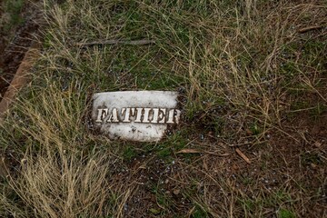Weathered Grave Marker with "Father" Text
