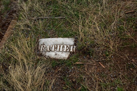 Weathered Grave Marker with "Father" Text
