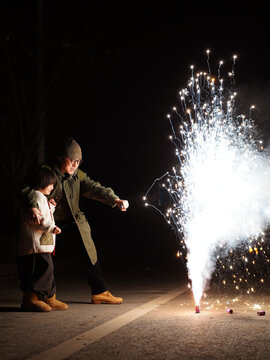 Asian boy and his father setting off fireworks