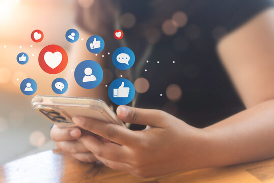 Woman hand hold smartphone and use social media network application to check new feedback or interactive with people and send emoticon for  react feeling and moment.