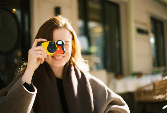 Smiling Woman Taking a Picture with Disposable Camera
