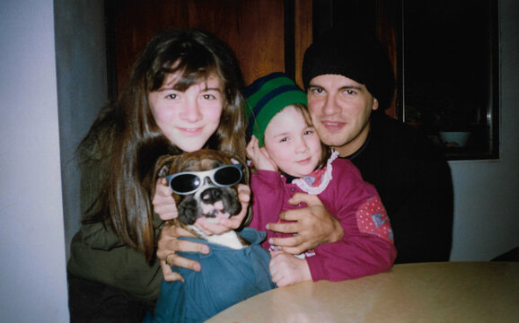 Uncle playing with his nieces and dog at the dining table