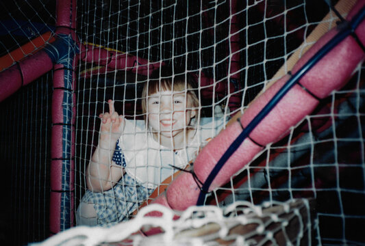 Little girl playing joyfully in a colorful ball pit