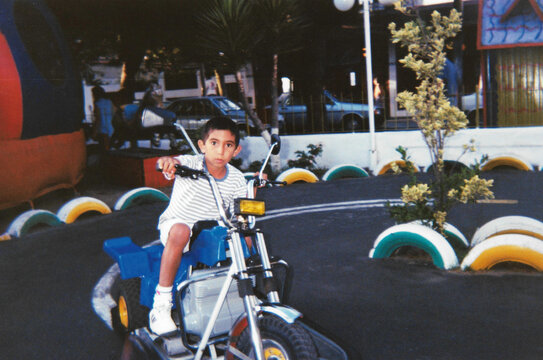 Boy riding toy motorcycle at fair