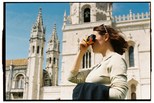 Woman photographing historic landmark with film camera