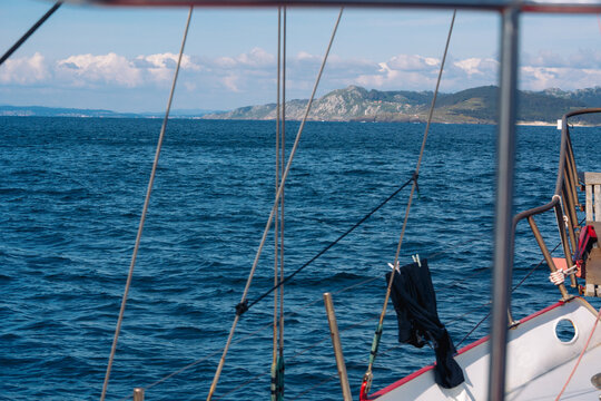 Distant coast seen through sailboat rigging