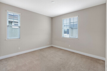 Bright and spacious empty residential rooms featuring natural light, neutral walls, and large windows. Ideal for real estate, interior design, and home staging themes.