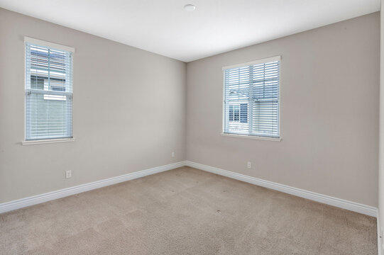 Bright and spacious empty residential rooms featuring natural light, neutral walls, and large windows. Ideal for real estate, interior design, and home staging themes.