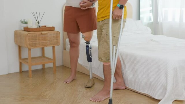 Closeup couple with leg prosthesis and walking forward in the bedroom