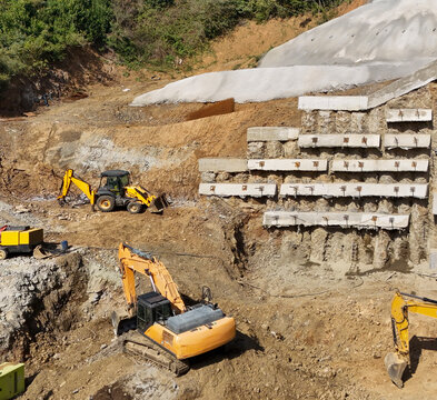 Excavators and Construction Equipment at a Hillside Construction Site.