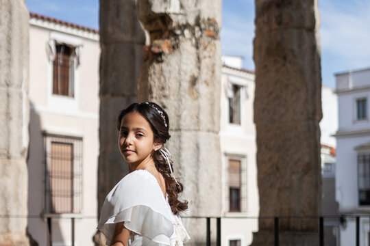 portrait of a happy girl in a pretty dress in a Roman temple
