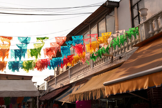 Colorful paper flags hang over an outdoor market