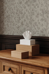 Elegant wooden boxes with tissue box on a tabletop with floral wallpaper