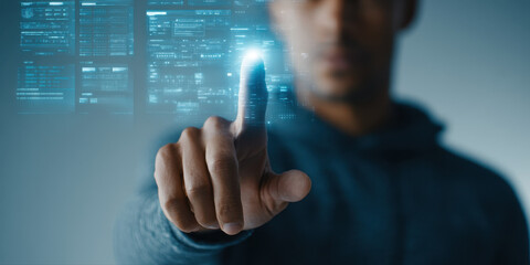 Man interacting with futuristic digital interface, pointing finger at glowing virtual screen with data and technology elements