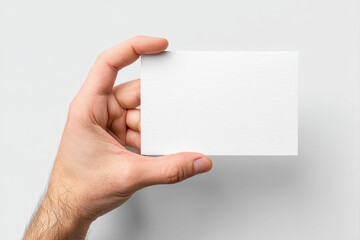 Close up of hand holding blank white card on light background, perfect for mockup or message with natural skin tone and clear details