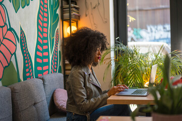 Young Professional Working on Laptop in a Stylish Modern Cafe Space