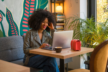 Professional Woman Working on Laptop in a Cozy Cafe Setting