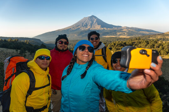 Hikers taking selfie with volcano in the background 