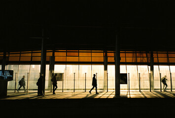 Silhouetted People at Train Station at Sunset
