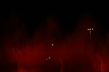 fountain background, water jets of a multi-colored fountain changing color on a black background, musical fountain