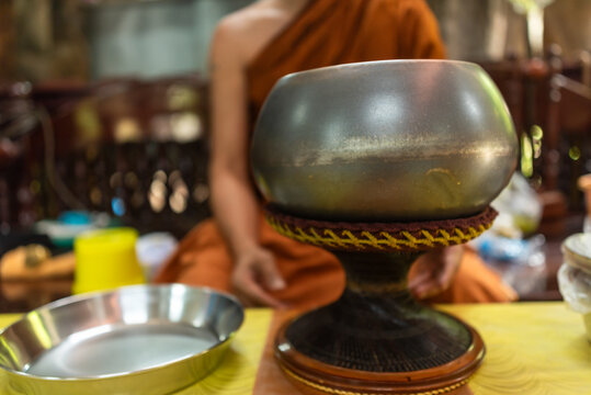 Thai Buddhist monk with his alms bowl during a temple merit ceremony