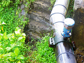 View of leaking pipes outdoors during the day.