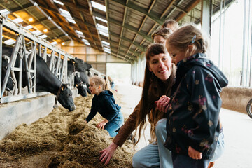 woman interacting with children at a dairy farm setting