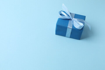 Gift box with a bow on a blue background, top view. Space for text