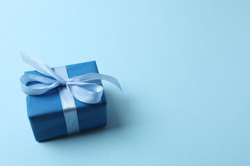 Gift box with a bow on a blue background, top view. Space for text