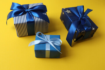 Gift box with a bow on a yellow background, top view. Space for text