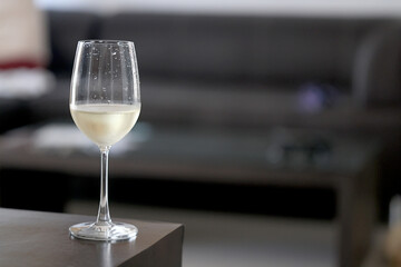 Wine glass close-up in real life, beautiful blurred background of the drink in the glass