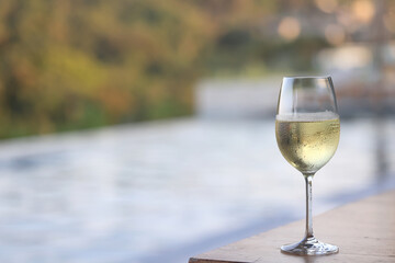 glass of cold white wine on the summer seashore by the water, relaxing by the water, a gentle background of soft color