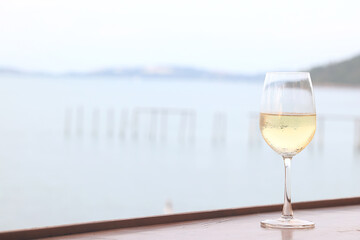 glass of cold white wine on the summer seashore by the water, relaxing by the water, a gentle background of soft color