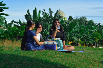 As their time outdoors winds down, one girl drinks while the others chat beside her, closing their...