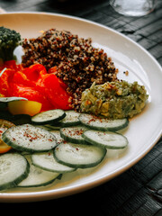 Fresh quinoa salad with vegetables and avocado dip served on a plate