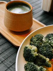 Fresh broccoli served with herbal tea in a cozy dining setting on a wooden table