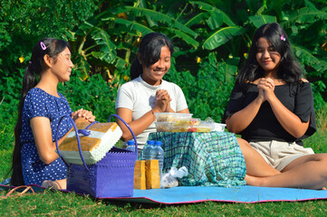 The three girls adopt a more serious demeanor as they resume their prayer together before eating,...