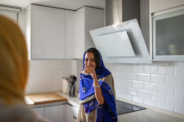 Arab Women Laughing and Chatting in a Cozy Kitchen.