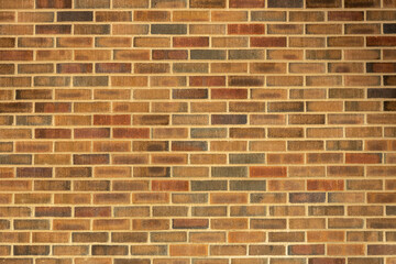 Abstract texture background of an exterior multi-shade reddish brown vintage brick wall surface speckled with blue, in traditional running bond brickwork pattern