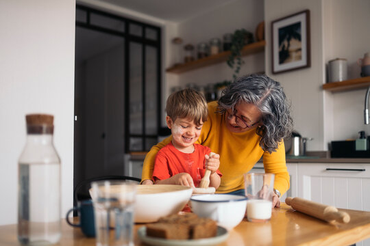 Grandmother and grandson baking together in kitchen