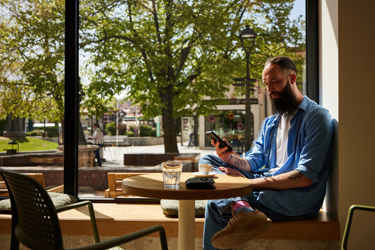 Calm man is sitting in a cafe