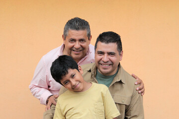 Three generations of a dark-skinned Latino grandfather, father, and son show their love and spend...