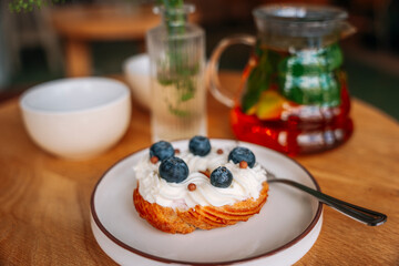 sweet dessert with berries in a cafe. rooibos tea and 2 tea cups are on the table nearby